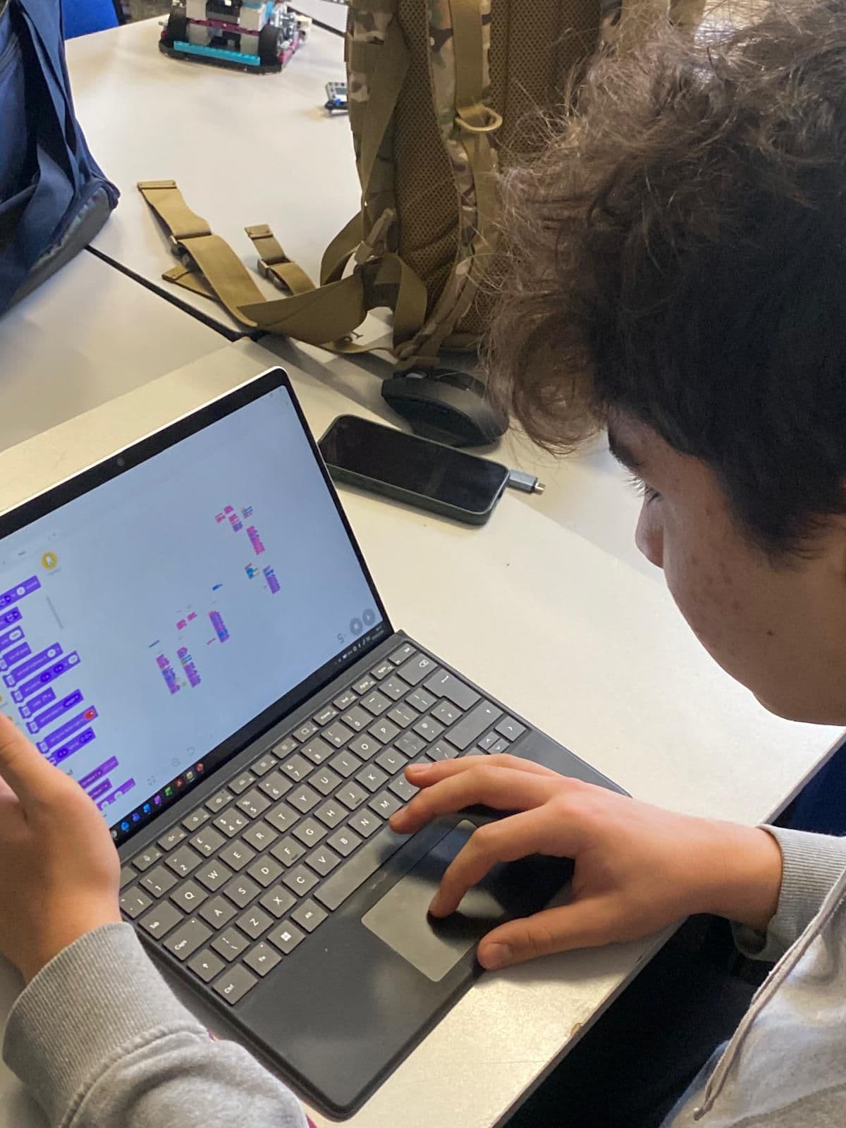 A team member writing code in Scratch / Word Blocks