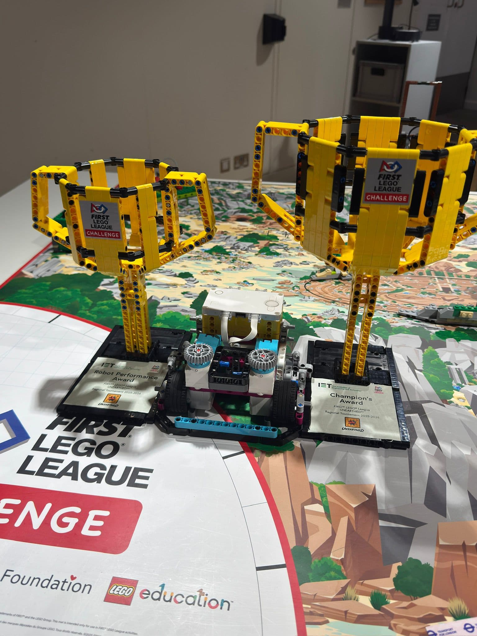 The robot flanked by two FLL Challenge trophies